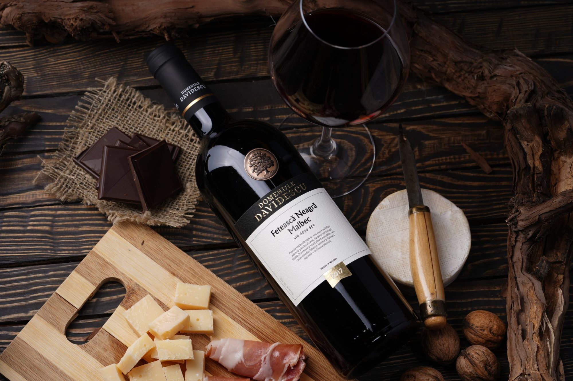 sticla vin rosu alaturi de preparate din carne si legume